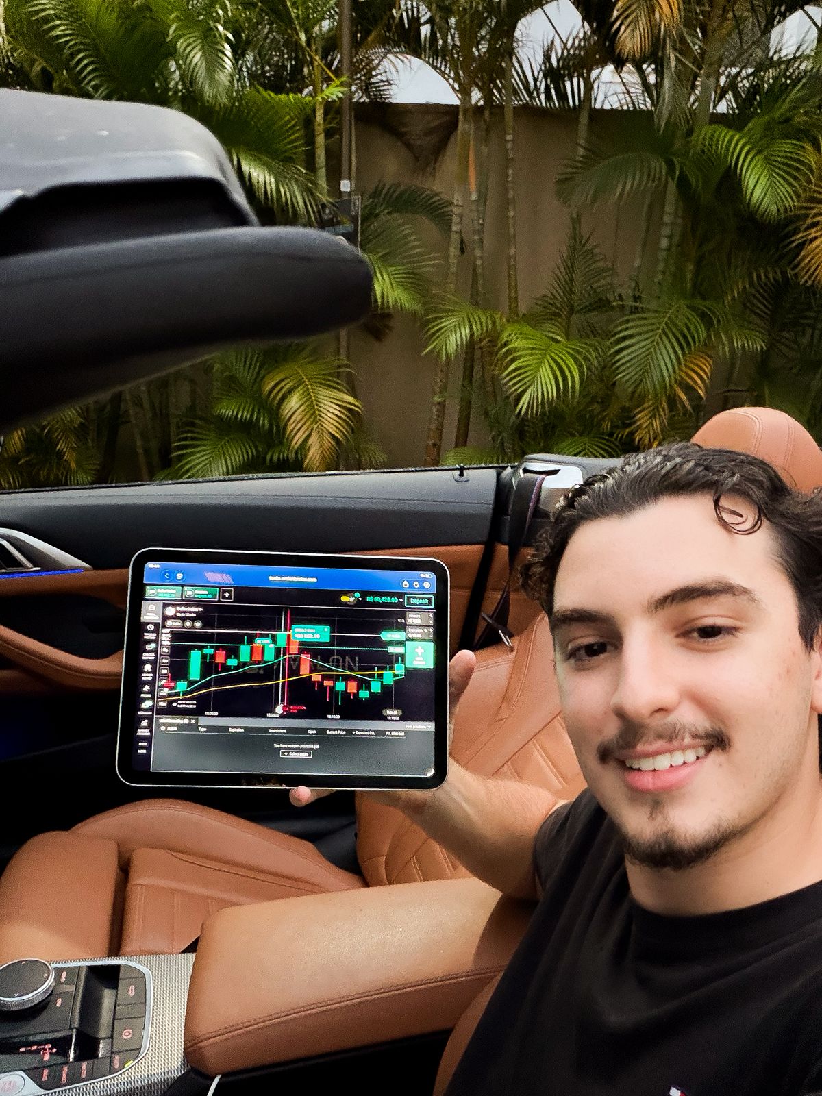 Criador do PH Trader segurando um tablet com o painel